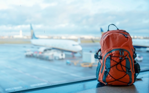 Orange,Backpack,In,An,Airport,Against,A,Plane.,Travel,Touristic Mochila Para Viajar En Avion: recomendaciones útiles | Remitly - Imagen 1